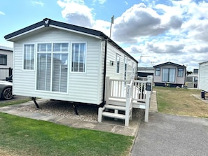 A mobile home with a porch and a small deck.