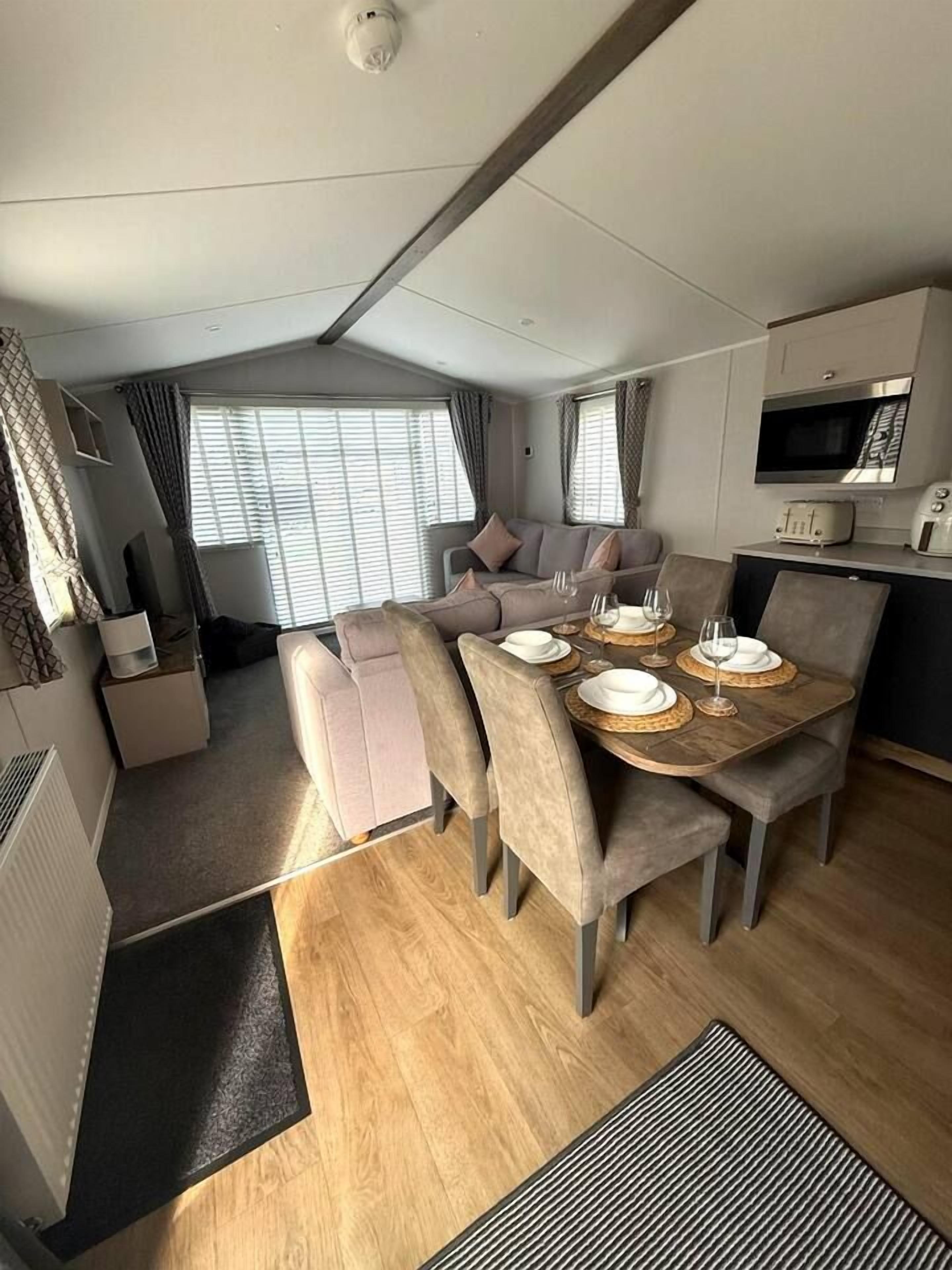 A compact living space with a dining area, kitchenette, and seating area.