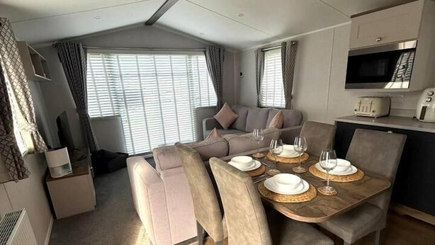 Un espacio habitable compacto con comedor, kitchenette y zona de estar.