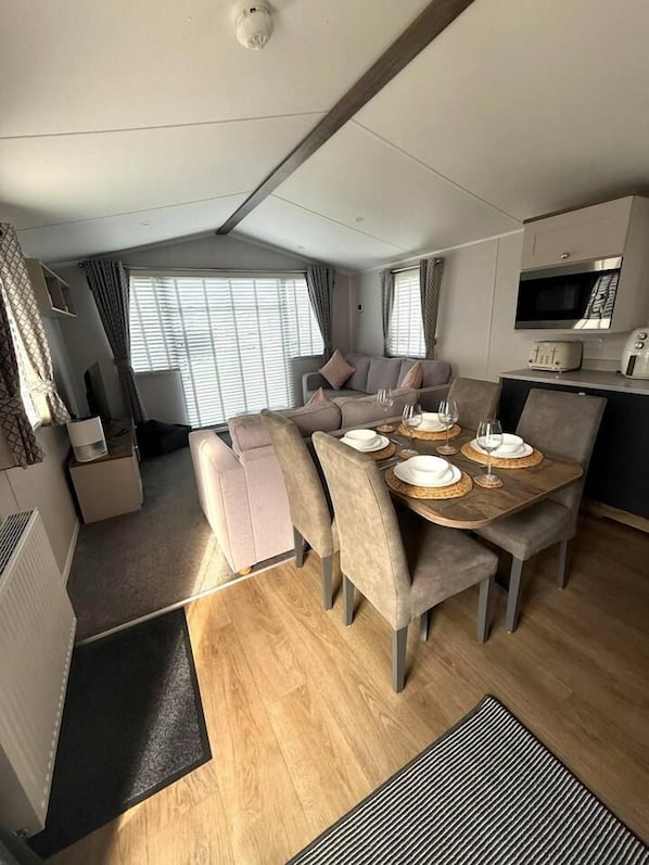 Un espacio habitable compacto con comedor, kitchenette y zona de estar.