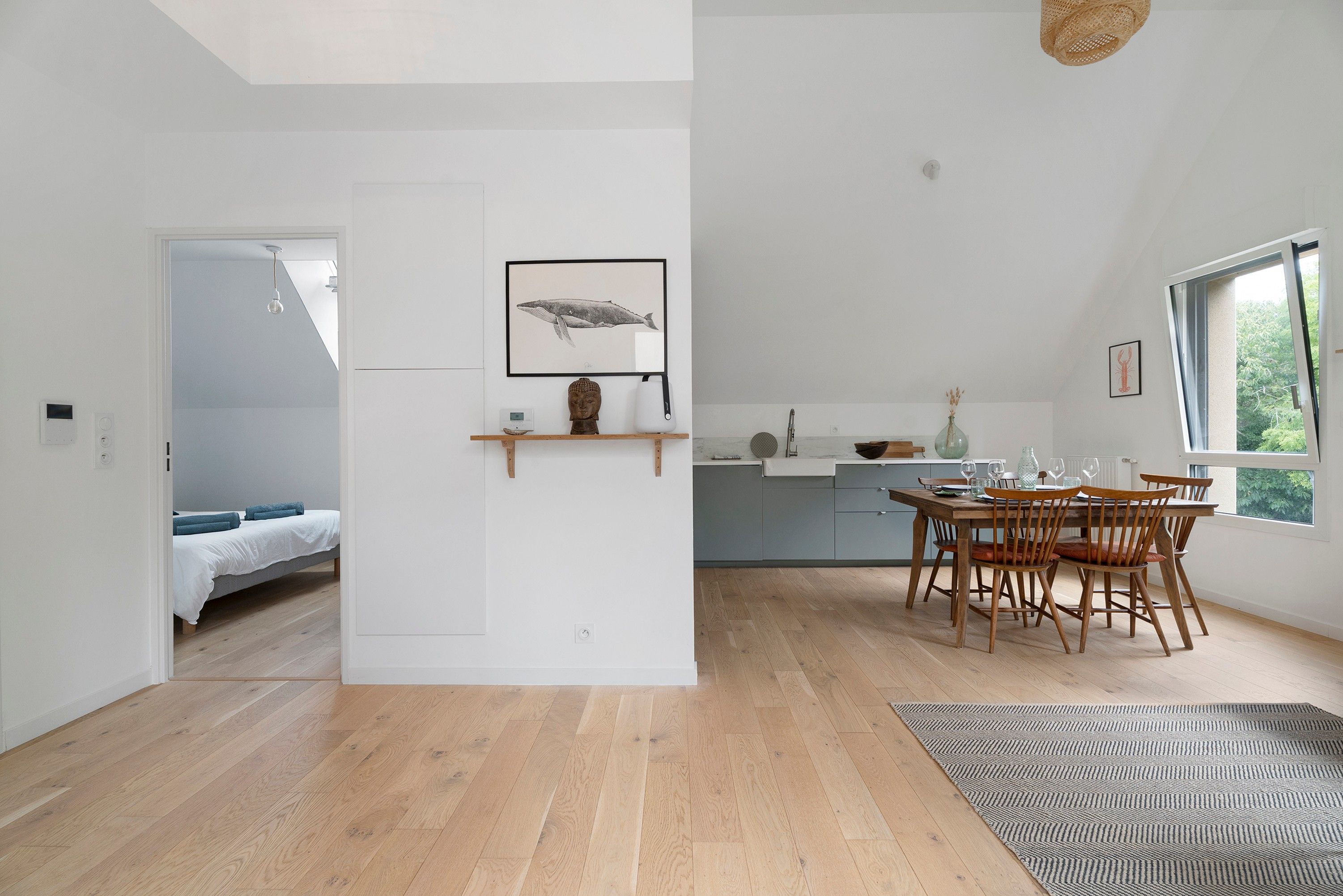 Un intérieur moderne avec une table à manger en bois, des chaises et un coin cuisine.