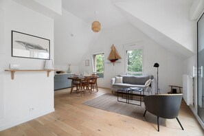 Un loft moderne comprenant un coin repas, un canapé et une grande fenêtre.