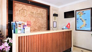 A reception desk with a wooden panel design, a sign for 'The Confetti Hotel', and a map of Vietnam. - The Confetti Hotel Ha Long (Hong Gai)