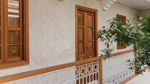A building with a balcony, wooden doors, and a white railing. - Riad L'Atelier (Marrakech)