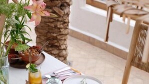 A dining table with a large bowl of stew, a glass of iced tea, and a potted plant. - Riad L'Atelier (Marrakech)
