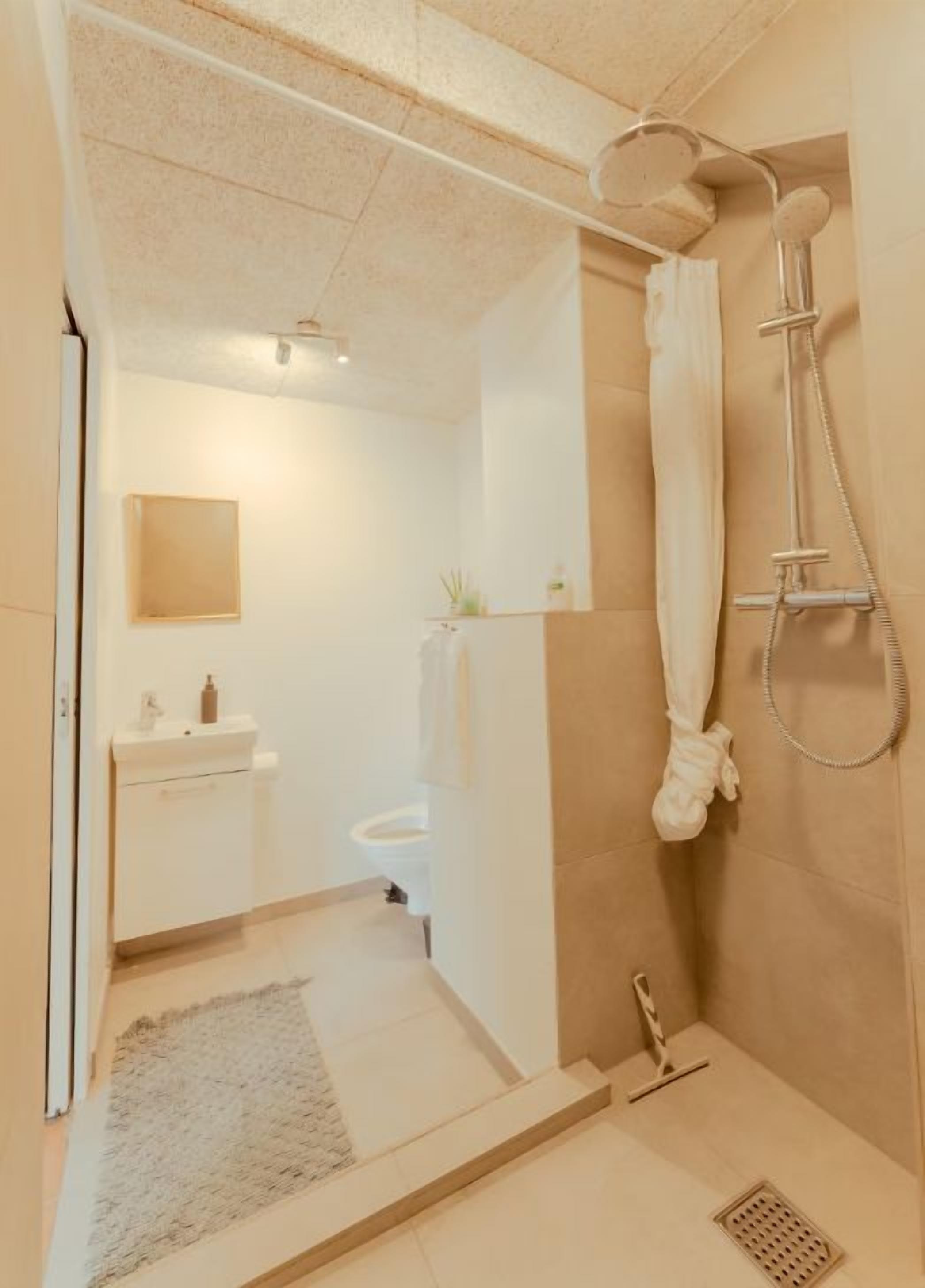 A bathroom with a shower, a toilet, and a sink.