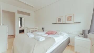 A modern bedroom with a bed, bedside table, and a mirror.