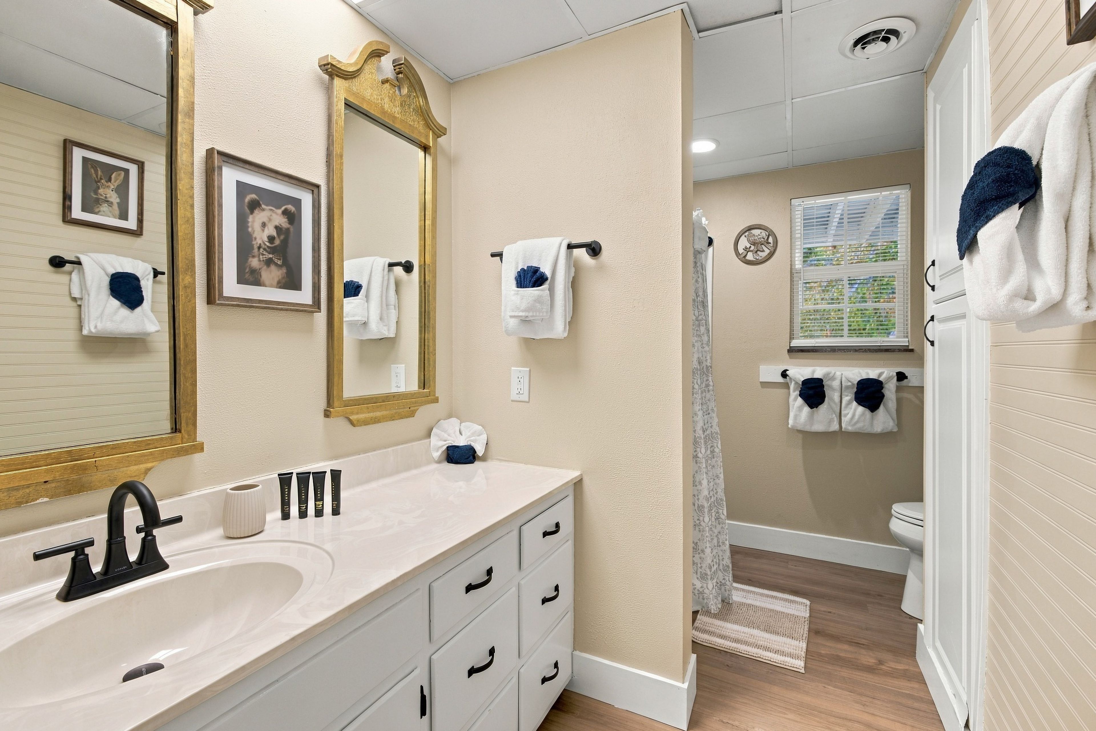 A bathroom with a large mirror, a sink, and a shower.
