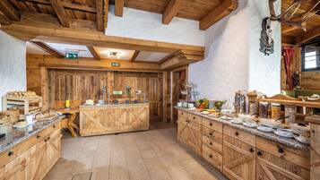 Un'accogliente interni in legno rustico con un'esposizione centrale a buffet, armadietti in legno e un soffitto a travi a vista.
