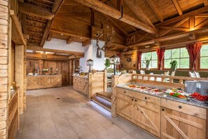 Un interior rústico de madera con una isla central, armarios de madera y un techo alto con vigas a la vista.