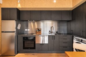 A modern kitchen with stainless steel appliances, a built-in oven, and a dishwasher.