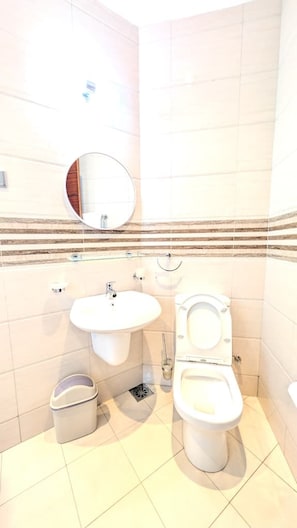A bathroom with a sink, toilet, and a mirror. - Le Cottage Mbale (Mbale)