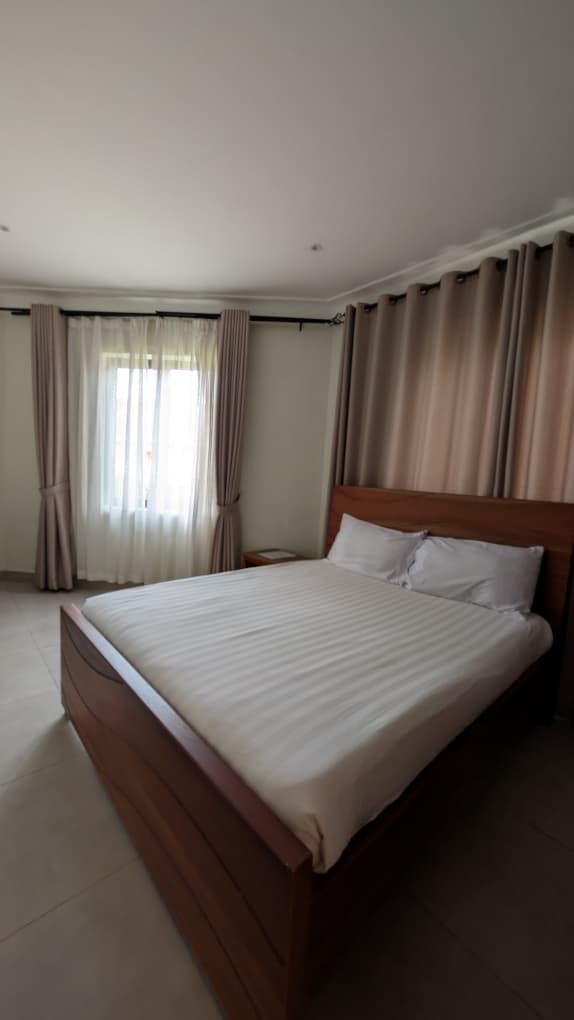 A large bed with a wooden headboard in a hotel room.