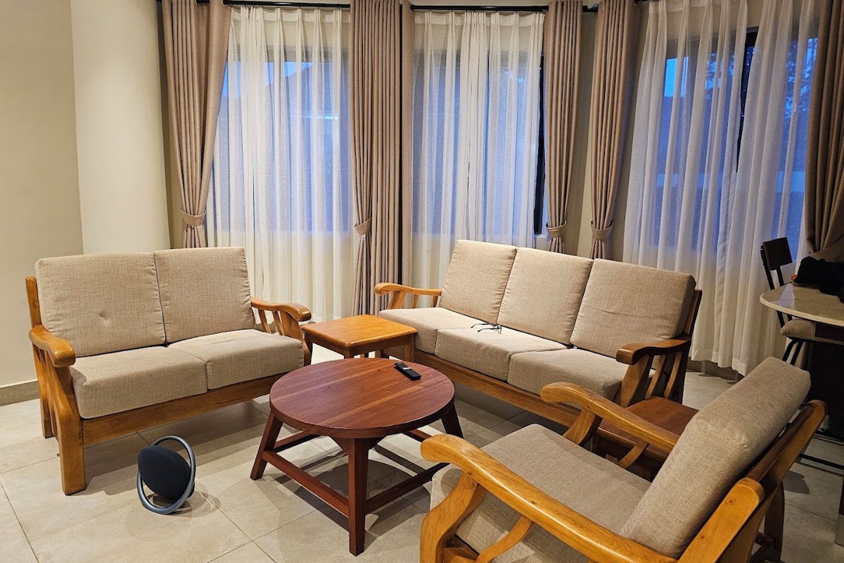 A living room with a sofa set, a coffee table, and a small table with chairs.