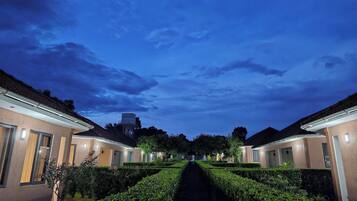 A pathway leading to a row of buildings with a clear sky overhead.