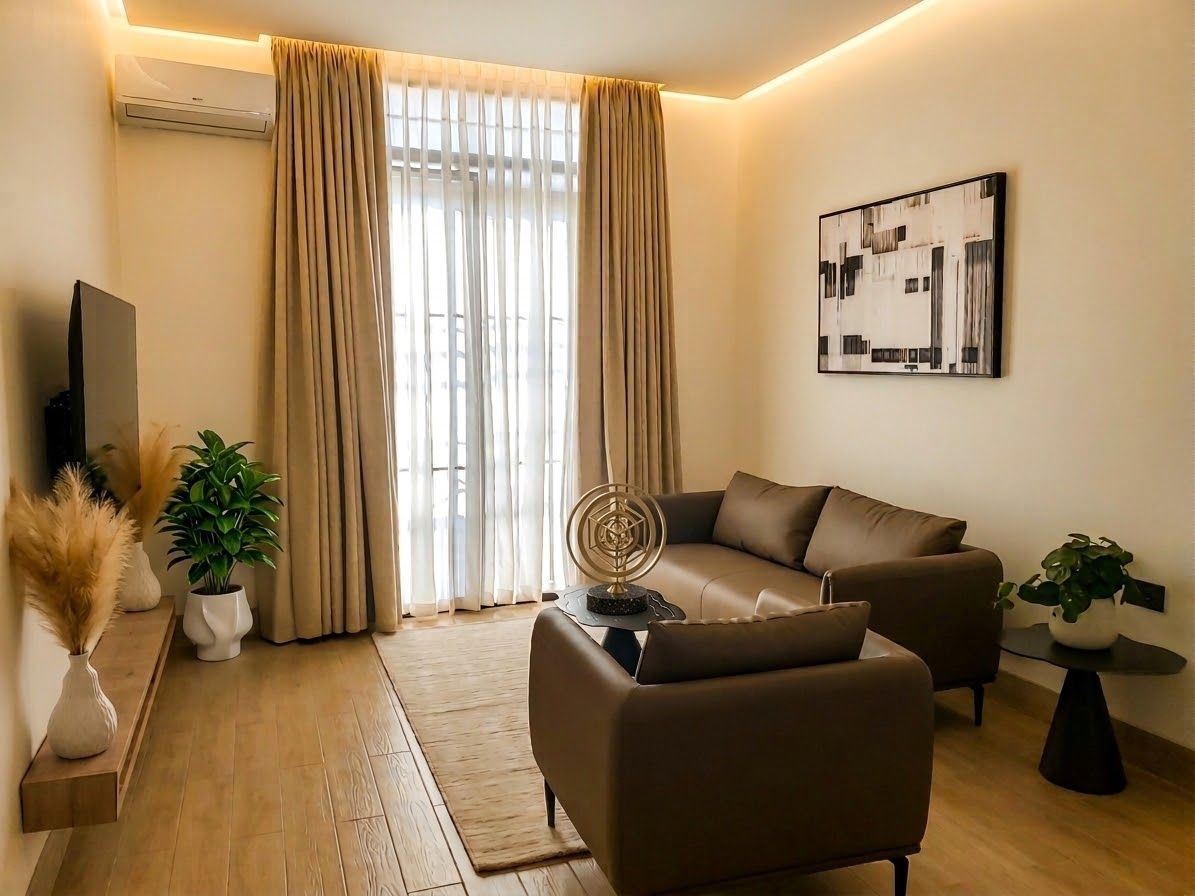 A modern living room with a sofa, a TV, and a painting on the wall.