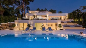 A modern multi-story house with a swimming pool, outdoor seating, and a well-maintained garden. - Vrbo Property (Nueva Andalucía)