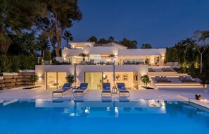 Ein modernes mehrgeschossiges Haus mit Swimmingpool, Außenbereich und gepflegtem Garten.