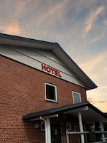 Un hotel con fachada de ladrillo rojo y techo blanco.