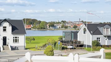 A residential area with houses, a body of water, and a clear sky.