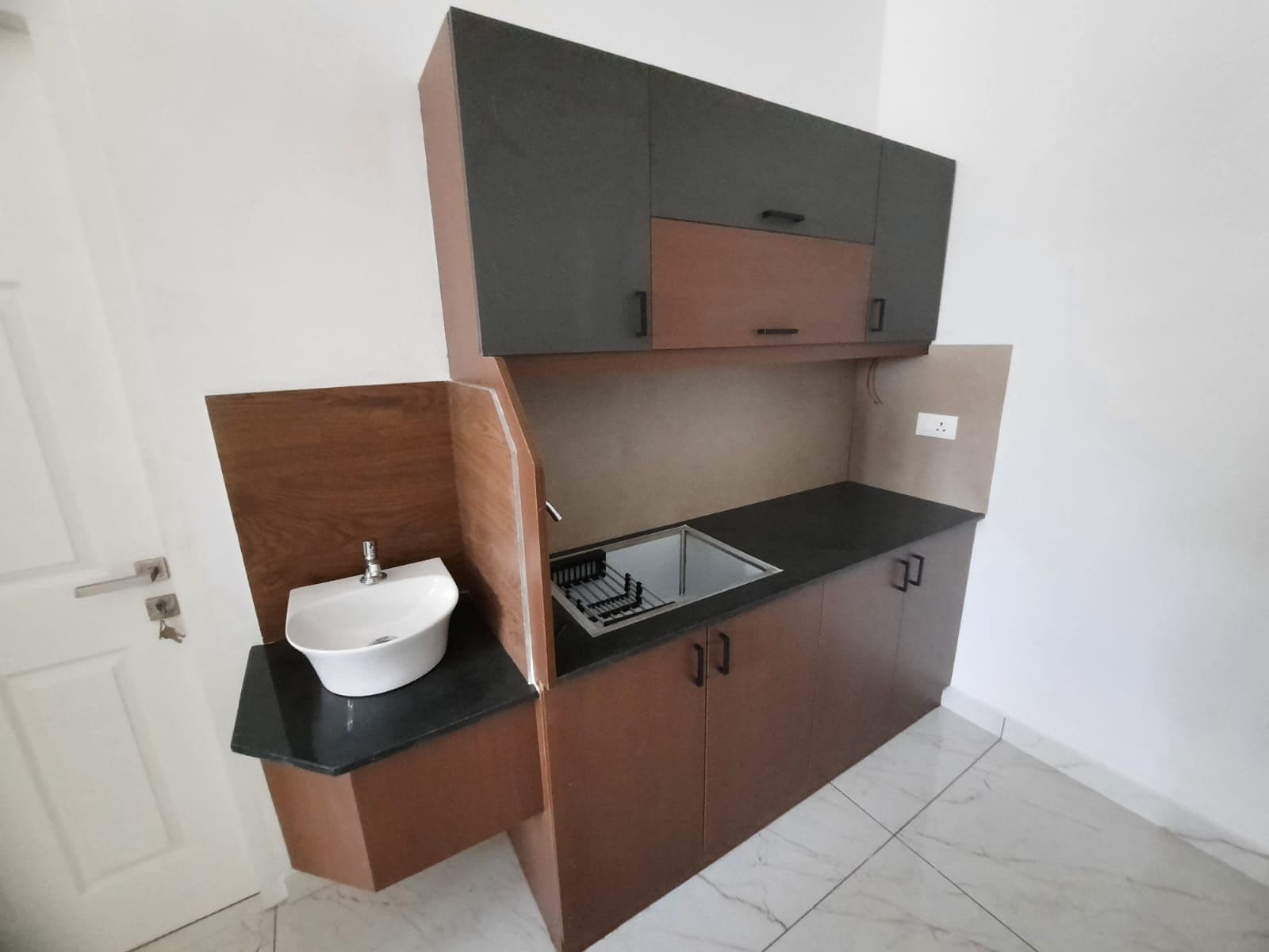 A compact kitchen with a sink, cabinets, and a countertop.