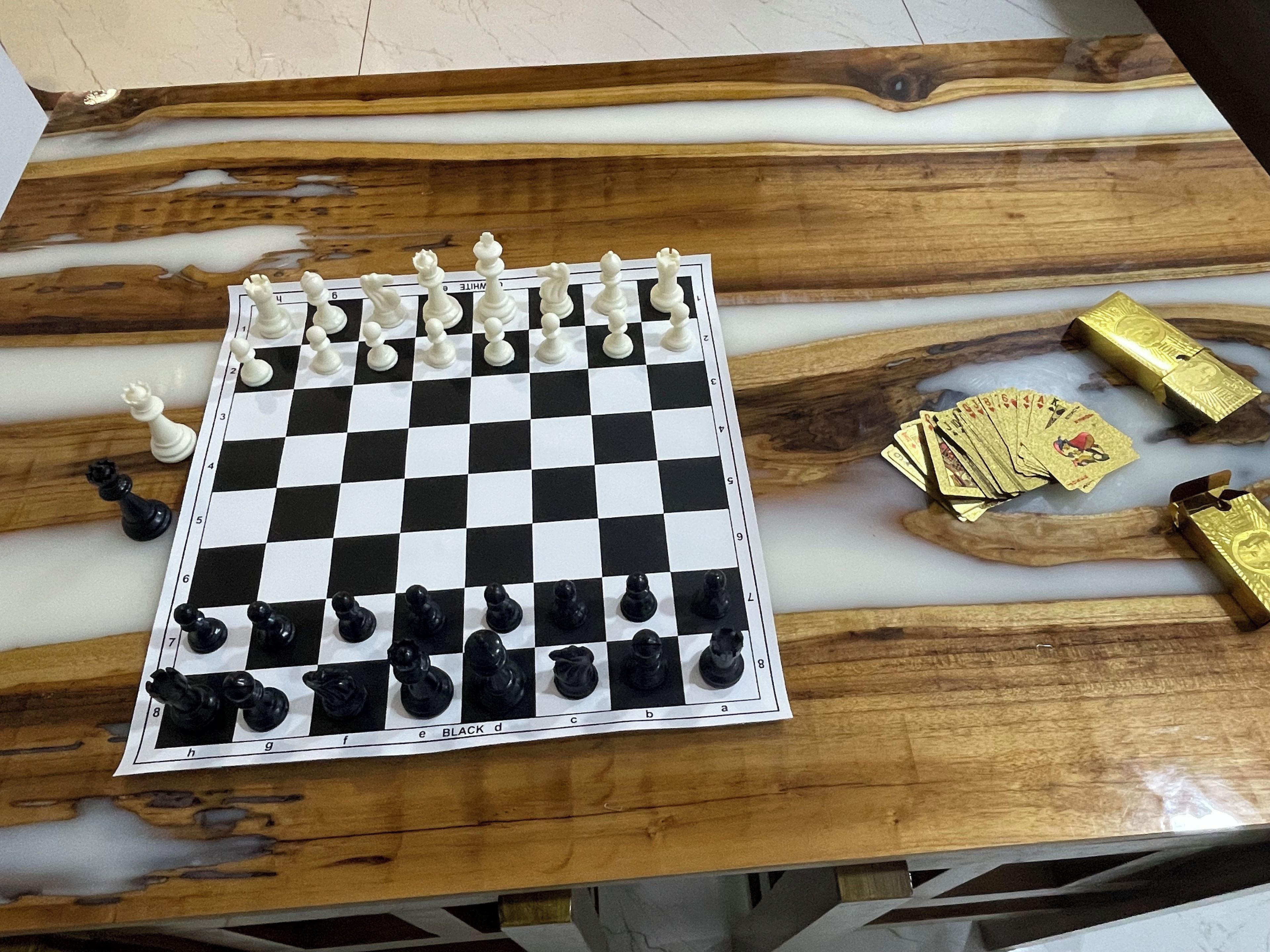 Um tabuleiro de xadrez sobre uma mesa de madeira com superfície semelhante a mármore.