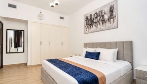 Quarto com cama, guarda-roupa, relógio e quadro na parede.