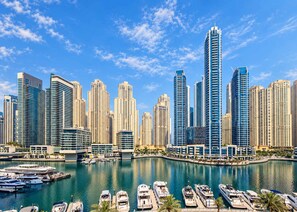 Marina com vários barcos atracados, cercada por edifícios altos.