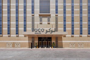 A building with a modern facade, featuring a prominent entrance with glass doors and a sign that reads 'VOCO'. - VOCO (Makkah)