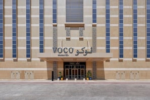 A building with a modern facade, featuring a prominent entrance with glass doors and a sign that reads 'VOCO'. - VOCO (Makkah)