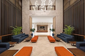 A spacious lobby with a reception desk, sofas, and potted plants. - VOCO (Makkah)