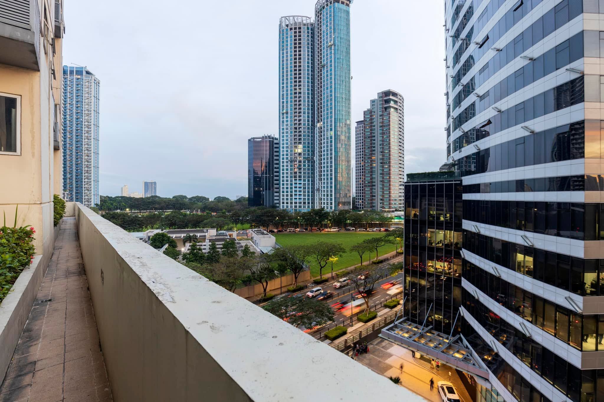 A high-rise building with a modern glass facade, surrounded by other tall buildings, and a view of a cityscape.