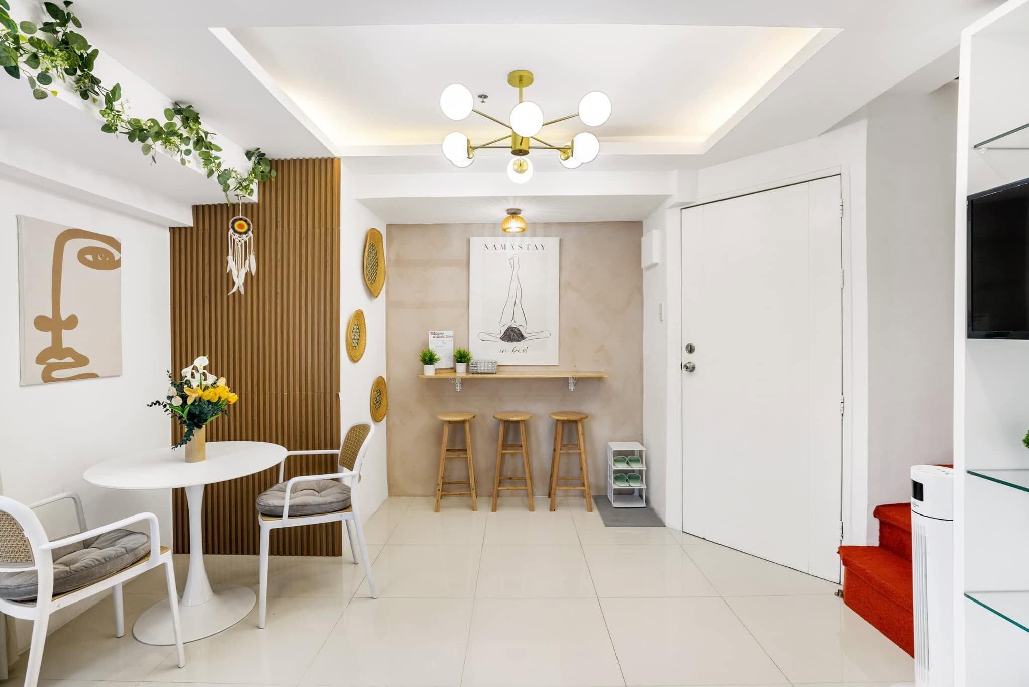 A modern interior with a dining area, a kitchen counter, and a white door.