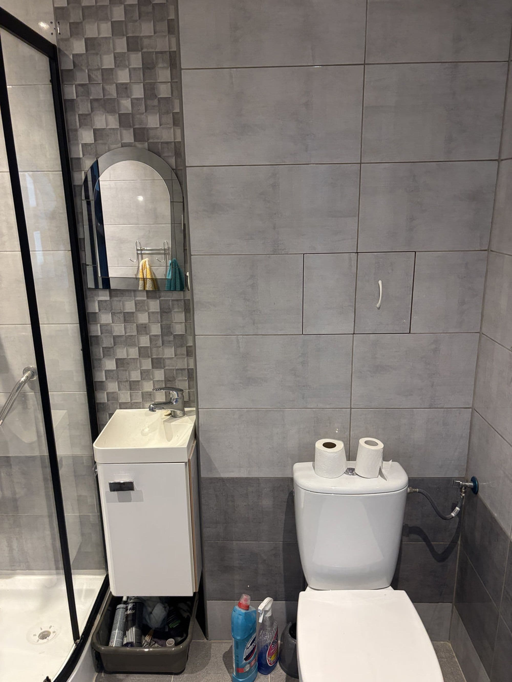 A bathroom with a shower, sink, and toilet.