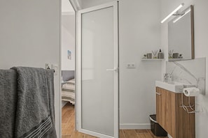Een moderne badkamer met een douche, toilet en wastafel.