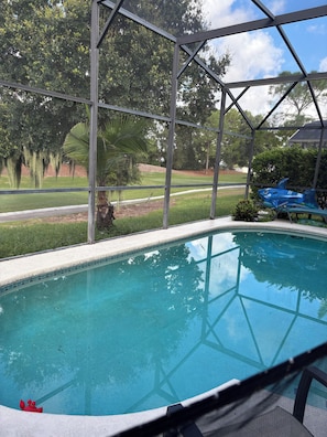 Una piscina con vistas despejadas al paisaje circundante, que incluye árboles y una carretera distante.