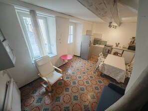 A compact kitchen with a dining area, a small table, and a chair. - Entire Rental: Townhouse - La Palme, France (La Palme)