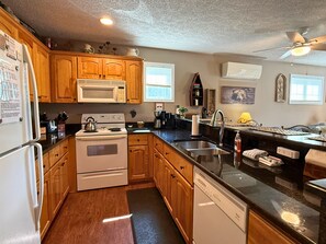 A kitchen with wooden cabinets, a stove, a microwave, and a dishwasher. - 2 bed condo, Seven Devils, close to it all! (Seven Devils)