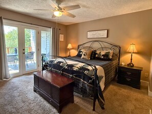 A bedroom with a bed, bedside lamps, a nightstand, a wooden bench, and a ceiling fan. - 2 bed condo, Seven Devils, close to it all! (Seven Devils)