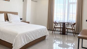 Une chambre d’hôtel avec un lit, une table et une chaise.