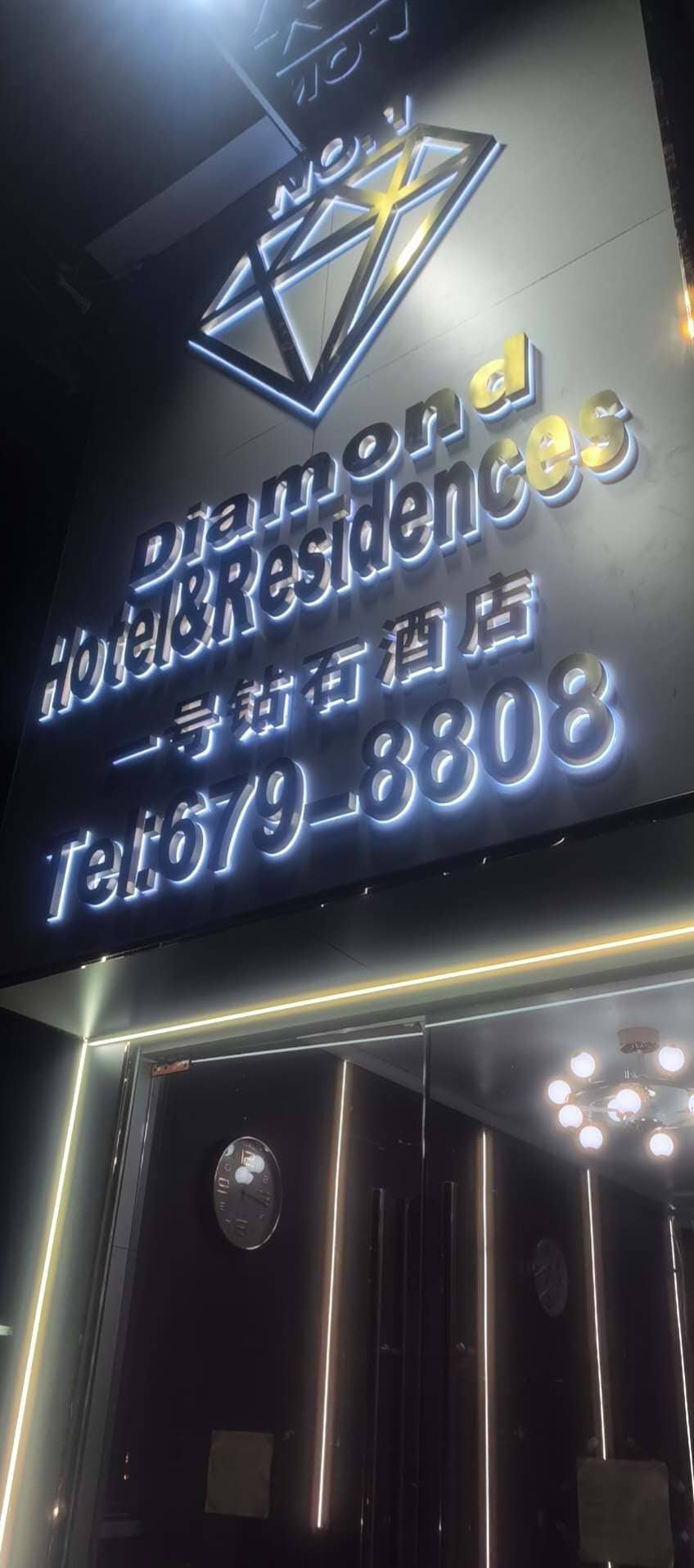 A hotel sign with the name 'Diamond Hotel Residences' and a phone number.