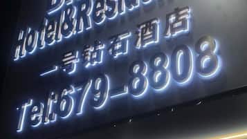 Un letrero de hotel con el nombre 'Diamond Hotel Residences' y un número de teléfono.