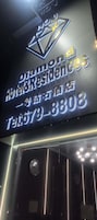 Un letrero de hotel con el nombre 'Diamond Hotel Residences' y un número de teléfono.