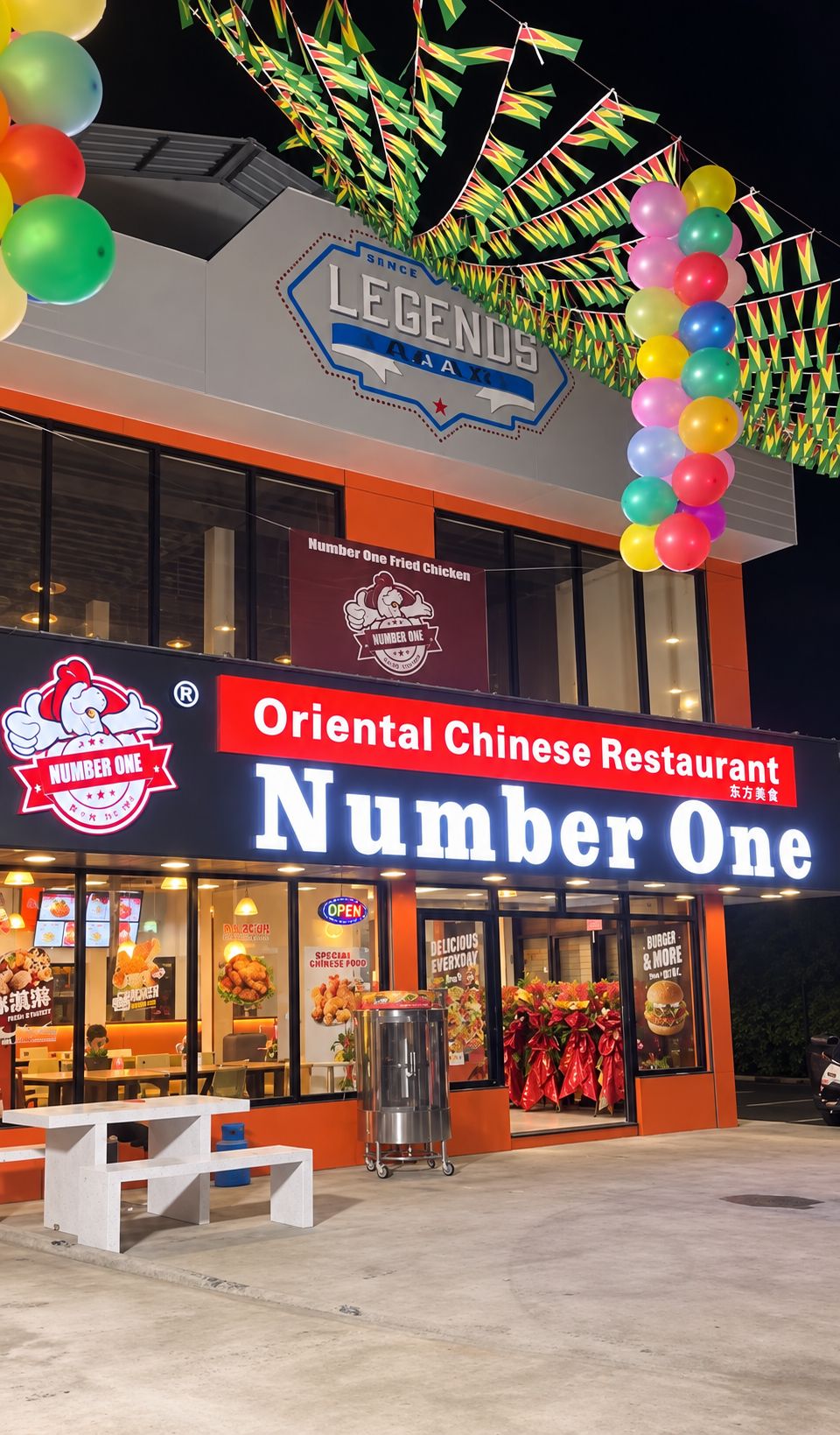 Restaurante chinês oriental chamado Number One, com um grande letreiro iluminado, mesas ao ar livre e decorações coloridas.