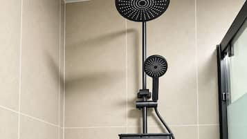 A modern shower with a handheld showerhead and a handheld massager.
