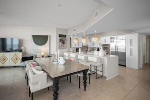 A modern kitchen with white cabinetry, a stainless steel refrigerator, and pendant lights. - Caribe BldgB-Fully Updated-Great Gulf Views-Orange Beach-Signature Properties (Orange Beach)