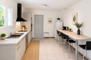A modern kitchen with a central island, a built-in oven, and a black range hood. - House with a pool in a quiet location (Saint-Michel-Escalus)