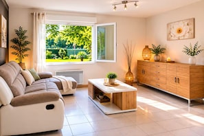 A modern living room with a sofa, a coffee table, a cabinet, and a window with a view of greenery. - House with a pool in a quiet location (Saint-Michel-Escalus)