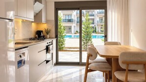 Una cocina moderna con comedor, vista a una piscina y un balcón.
