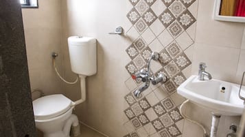 Un baño con inodoro, lavamanos empotrado y ducha.